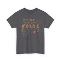 Faith-based “ABIDE” graphic t-shirt with tree, leaves, and fruit illustration on a dark gray tee inspired by John 15.