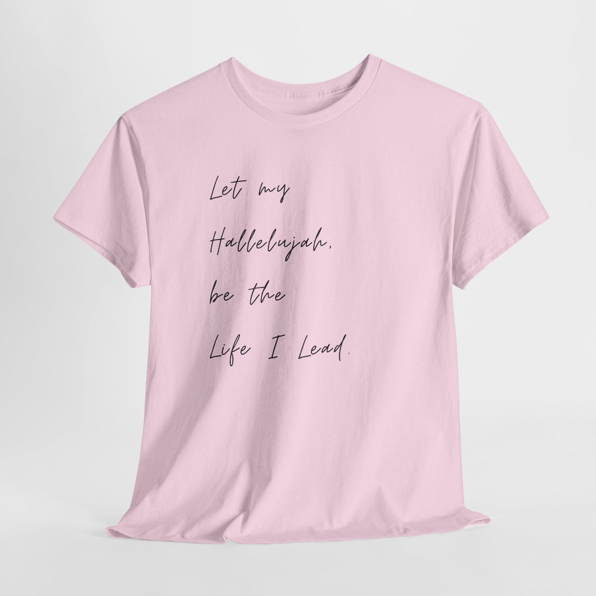 Light pink Christian t-shirt featuring the phrase "Let My Hallelujah Be the Life I Lead" in elegant black script on the front.